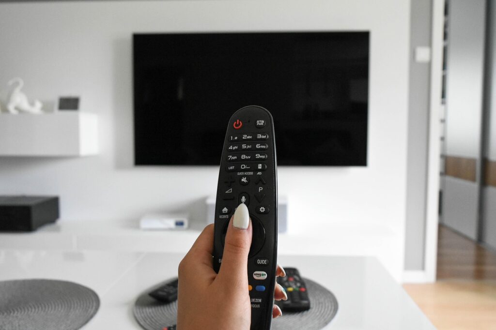 テレビ前でリモコンを操作している